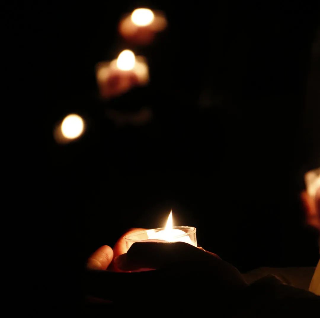 全场师生手捧蜡烛,为南京大屠杀遇难同胞默哀.