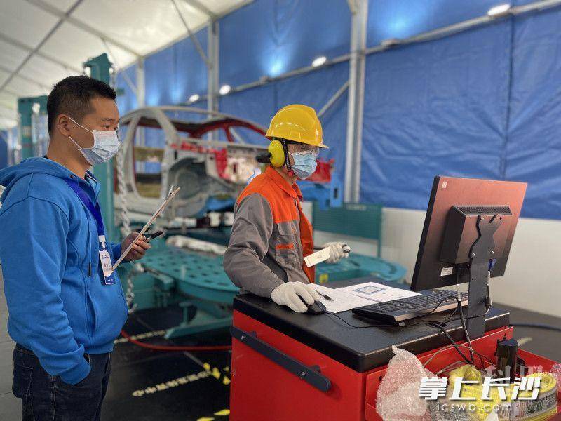 在车身修理项目现场，1号选手正在测量汽车车身损伤及变形的程度。