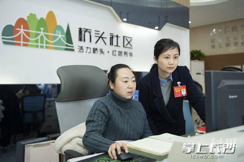 康姣在和同事一起处理社区工作。