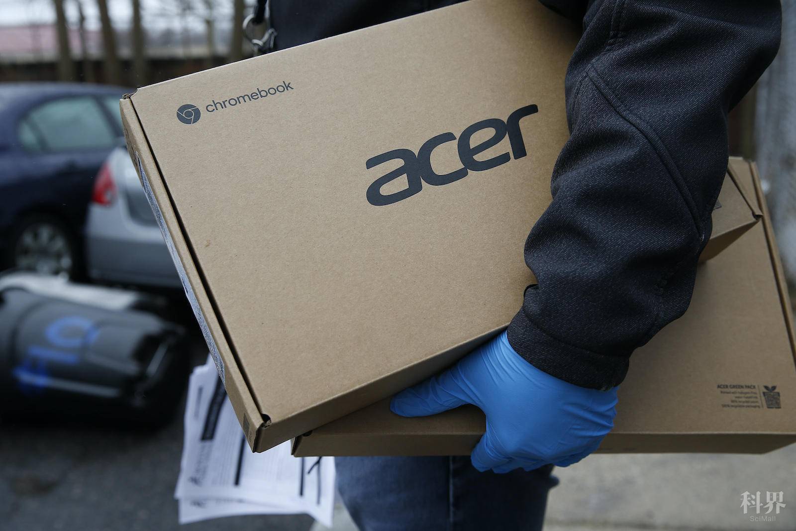 BOSTON, MA - MARCH 19: Boston Public Schools employee Giscar Centeio holds two laptops as he does a dry run going door to door handing out Acer chromebooks to students in Boston on March 19, 2020. Students have to do classwork from home now that all Massachusetts schools have closed to stop the spread of coronavirus. (Photo by Jessica Rinaldi/The Boston Globe via Getty Images)