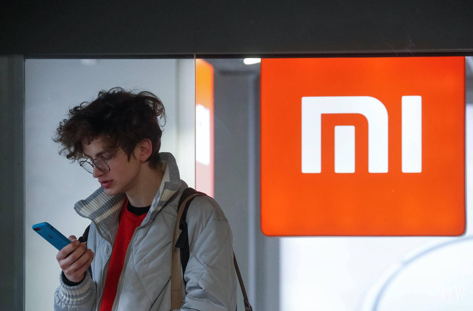 A man uses his smartphone next to the Xiaomi brand's store in central Kiev, Ukraine February 11, 2020.REUTERS/Valentyn Ogirenko - RC2DYE9G9UVU