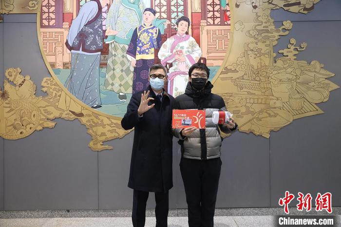 京港地铁运营副总经理姜宜荣(左)在16号线达官营站为首位乘客赠送开通礼物。　京港地铁供图